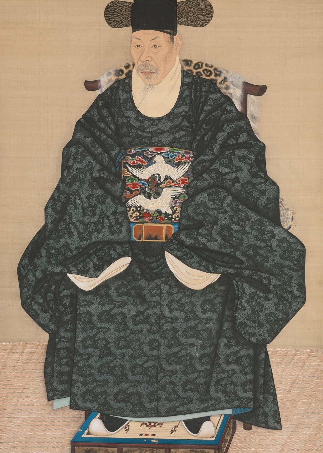His upright posture and formal pose communicate a sense of gravitas and self-possession.
