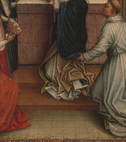 A man kneels in the corner, hands pressed together.