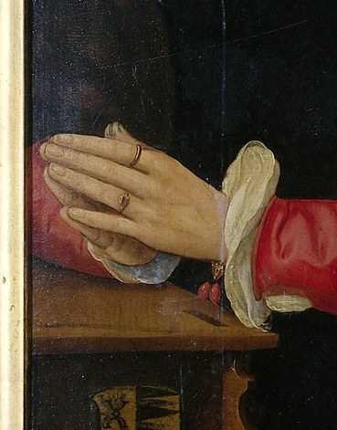 See her hands, adorned with rings.