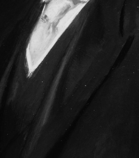 His sharp suit and crisp tie show the formal attire of the era.