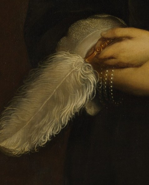She holds a delicate feather fan.
