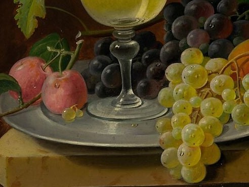 Contrasts in color and translucency with the dark grapes above; the downward cascade creates visual movement toward the plate below and invites the eye to linger on each translucent globe.