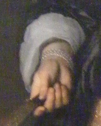 One hand rests on a hand fan.
