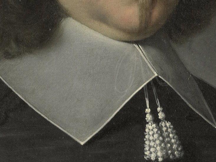 His meticulous collar and lace speak to his status.