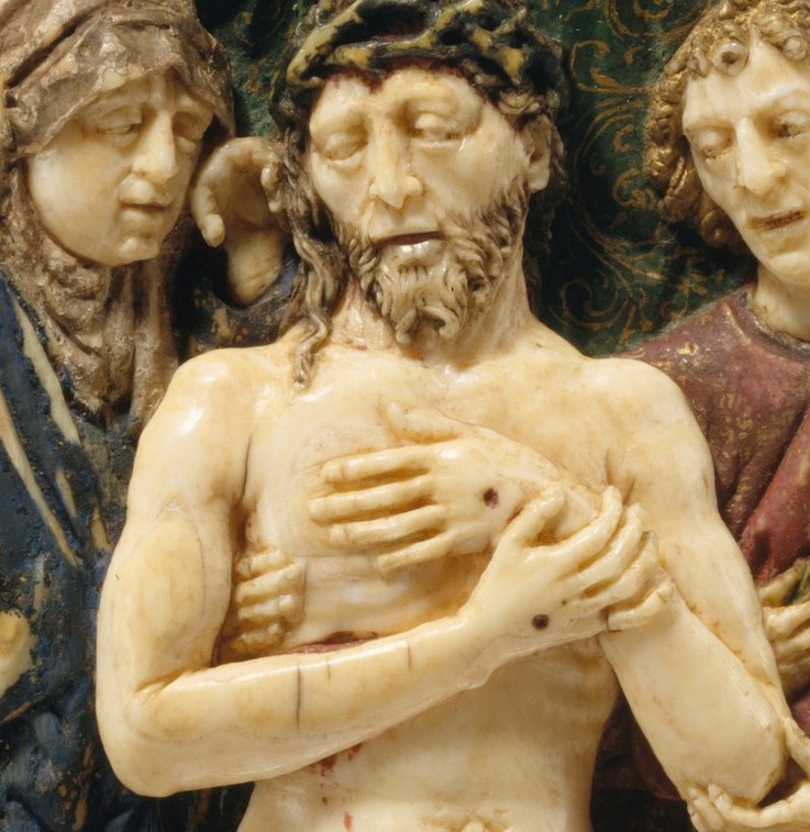 Look closely at his bare chest and clasped hands.