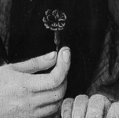 His delicate hand holds a single, symbolic flower.