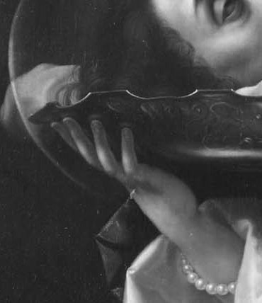 Her hand holds the platter with the head.