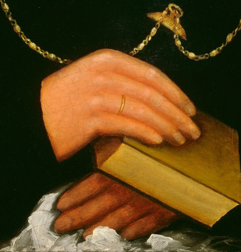 Look at her hands, gently holding an open book.