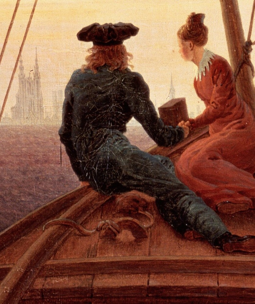 The man stands by the mast, his back to us.