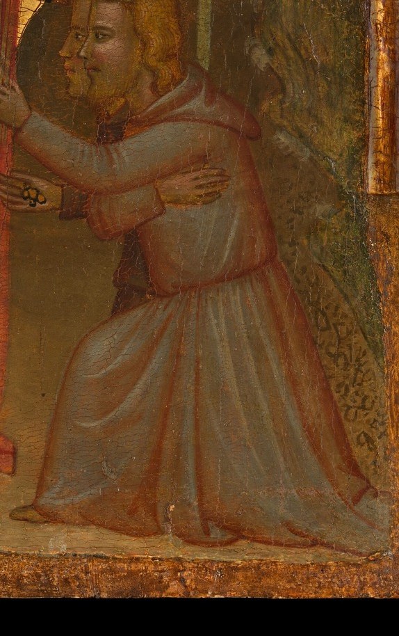 A kneeling child holds something tight against their chest.