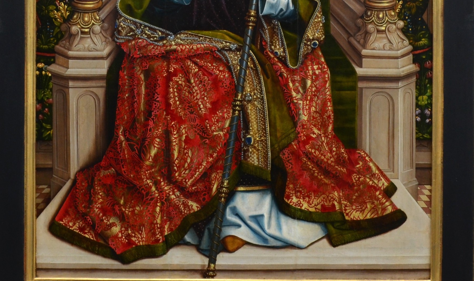 His robes are rich red and gold.