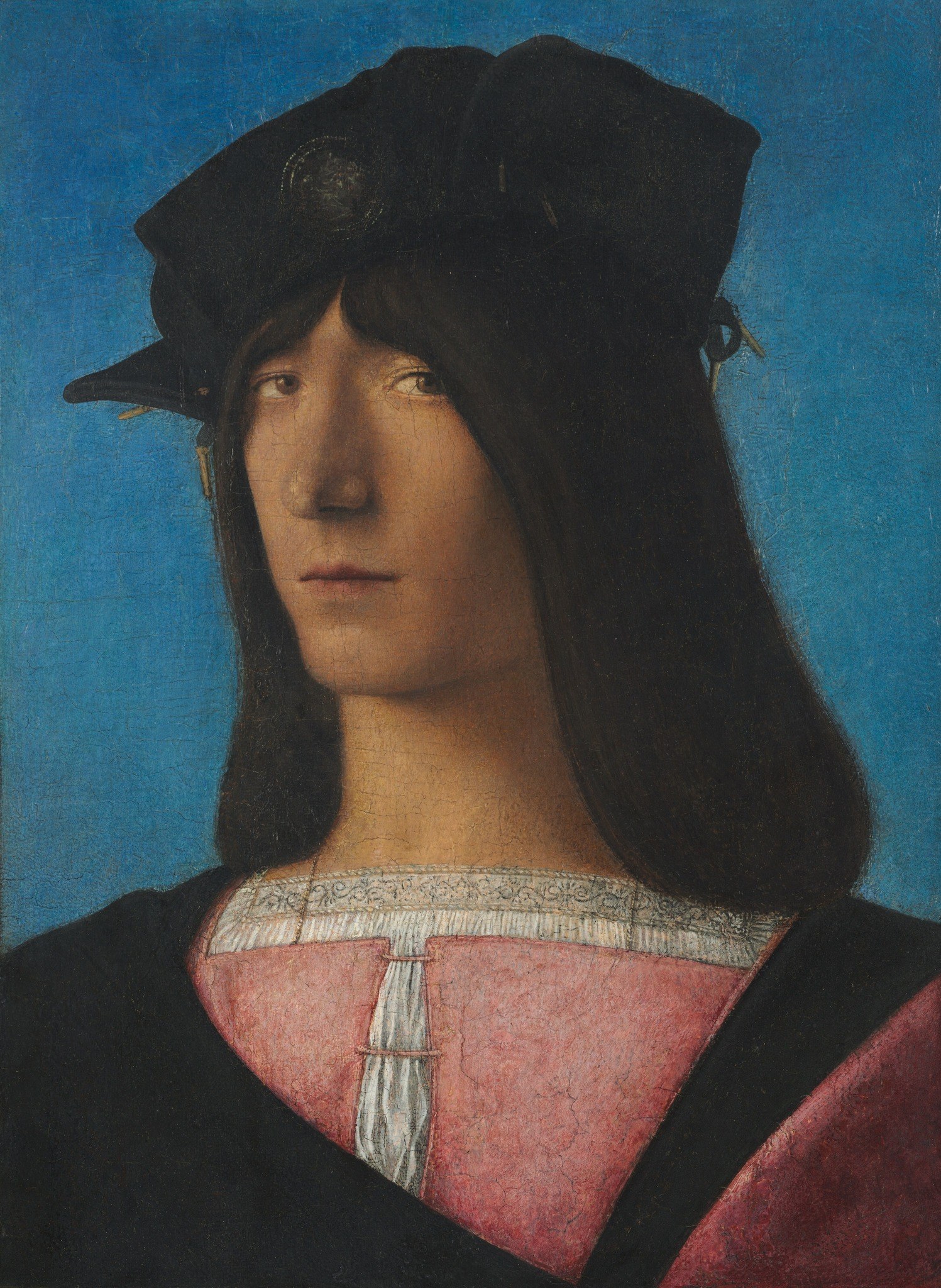 The uniform, vibrant blue creates a sense of depth and isolates the subject, making his features stand out more prominently.