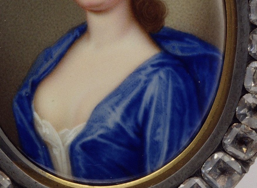 She wears a delicate blue gown and a flower in her hair.