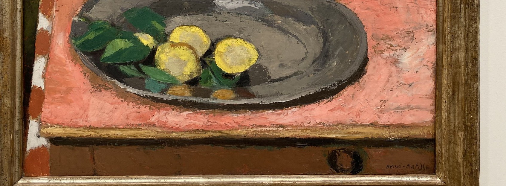 The vibrant yellow lemons contrast with the muted pink tablecloth.