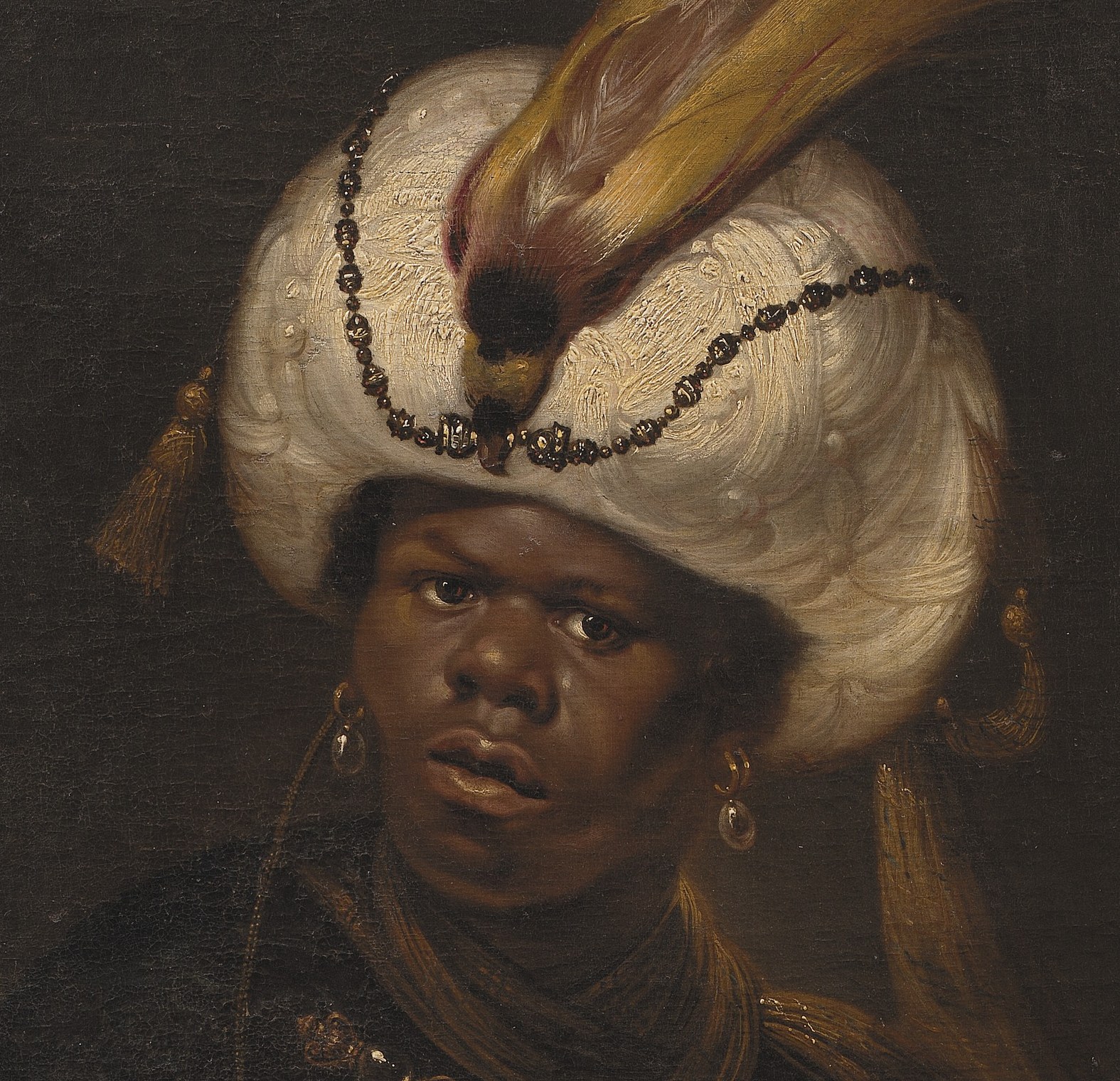 His turban is white, with a feather.