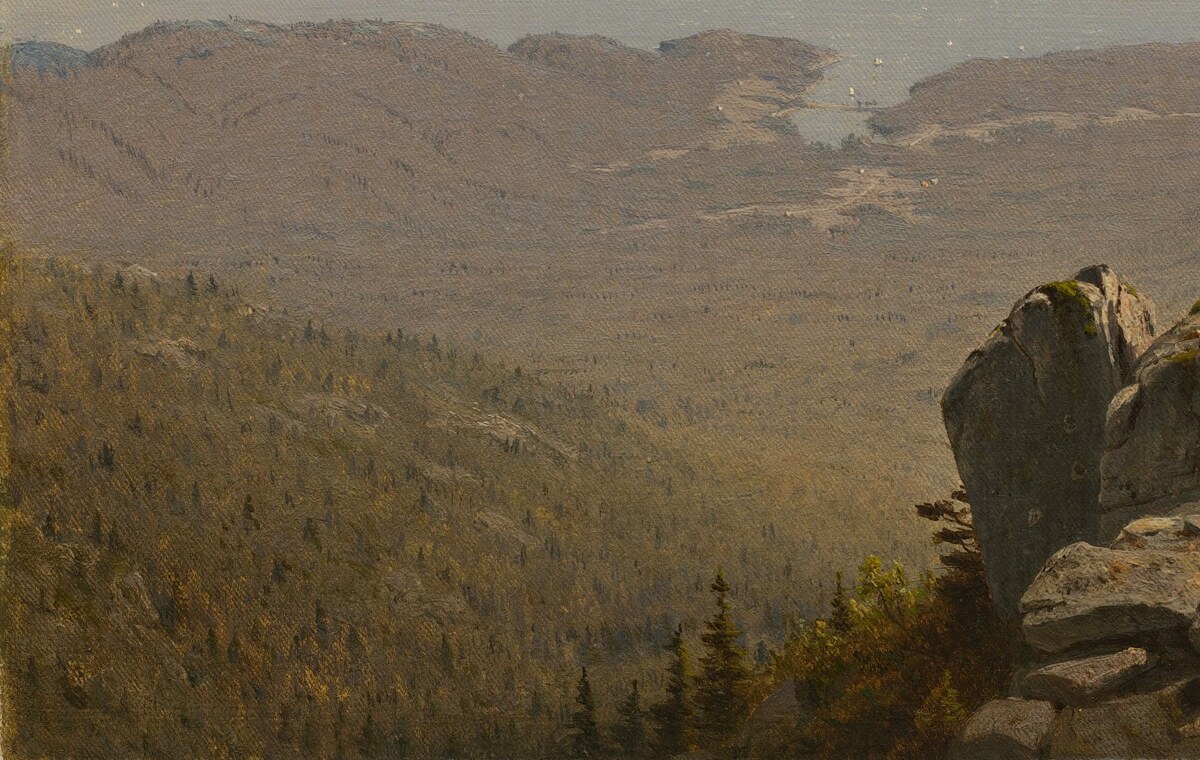 The high-contrast dark rock anchors the composition and makes the luminous distance feel earned; its rough texture contrasts with the silken haze beyond
