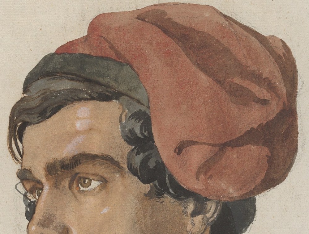 His distinctive red and black turban immediately signals his identity.