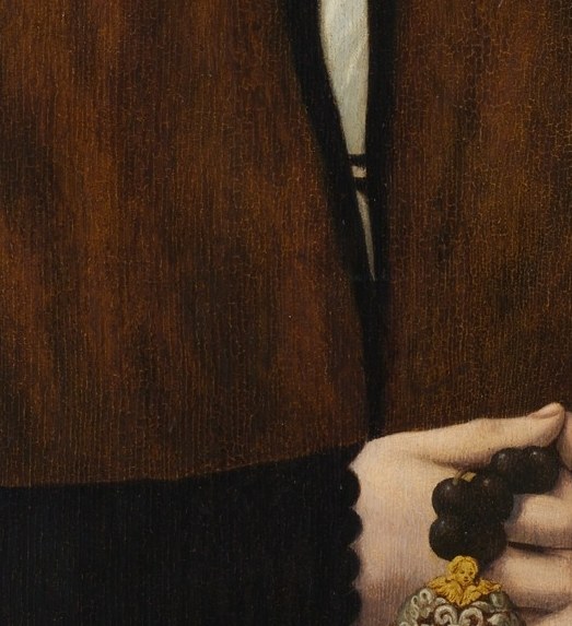 In his right hand, he presents a crucial piece of his identity.