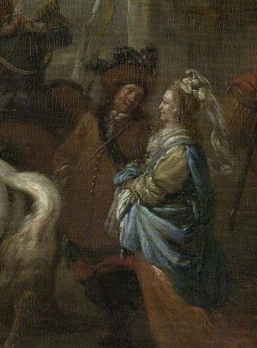 A woman on a white horse leads a party from a villa.
