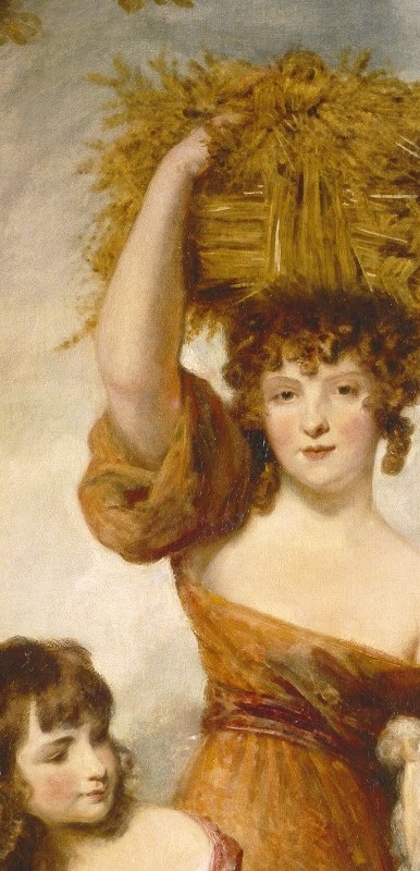 A woman balances hay on her head.