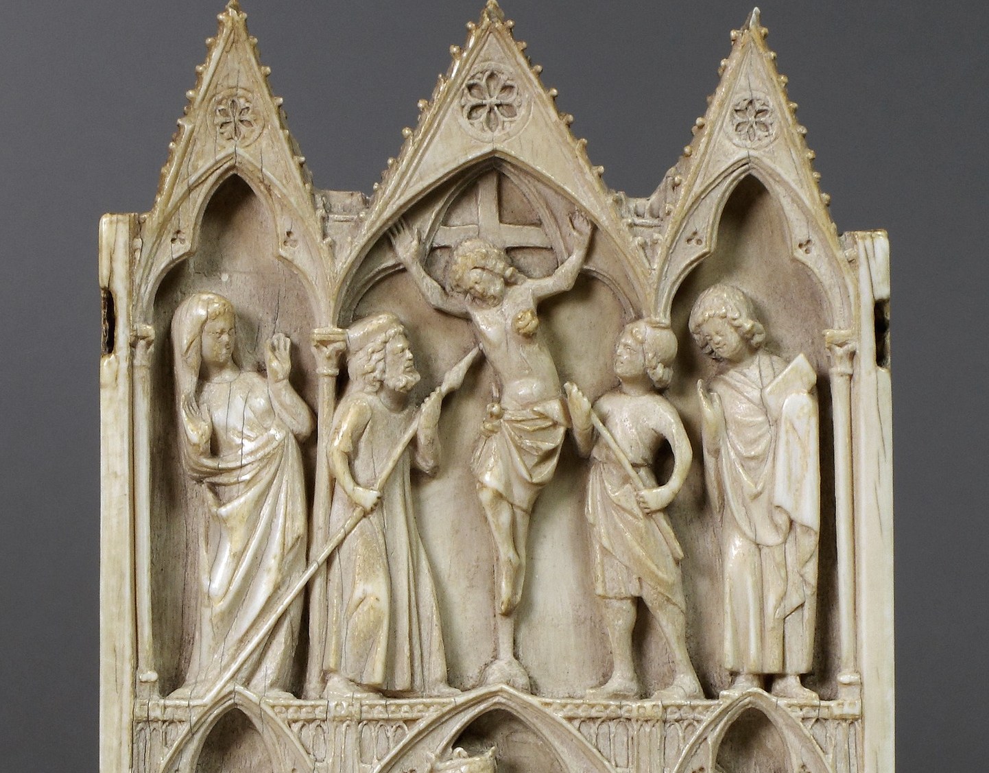 The architectural framing is itself a sculptural feat , delicate crocketed pinnacles in ivory demonstrate the carver's virtuosity at this miniature scale