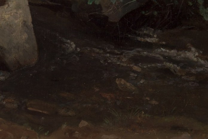 This quiet girl sits by a stream.