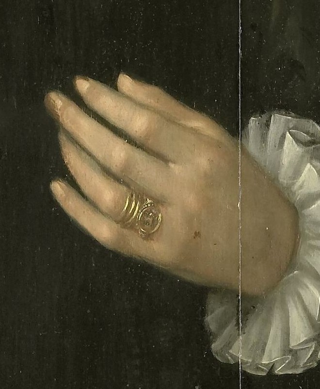 The modest ring on his hand suggests his marital status.