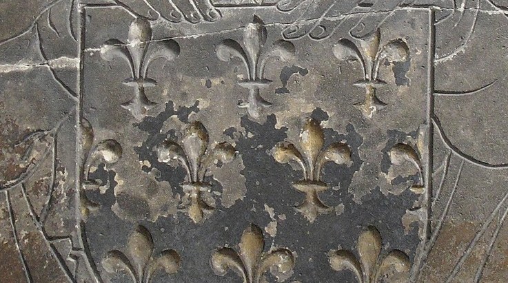 A winged angel holds her heraldic shield, now damaged.