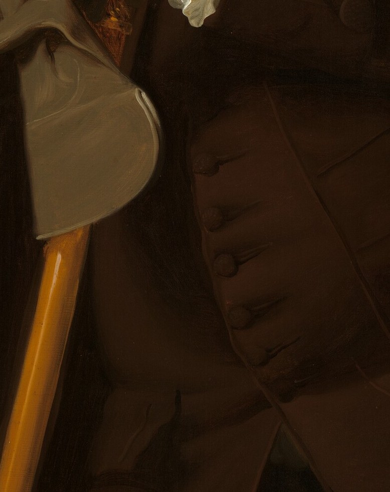 His hand rests easy on the cane. A man who expects to be heard.