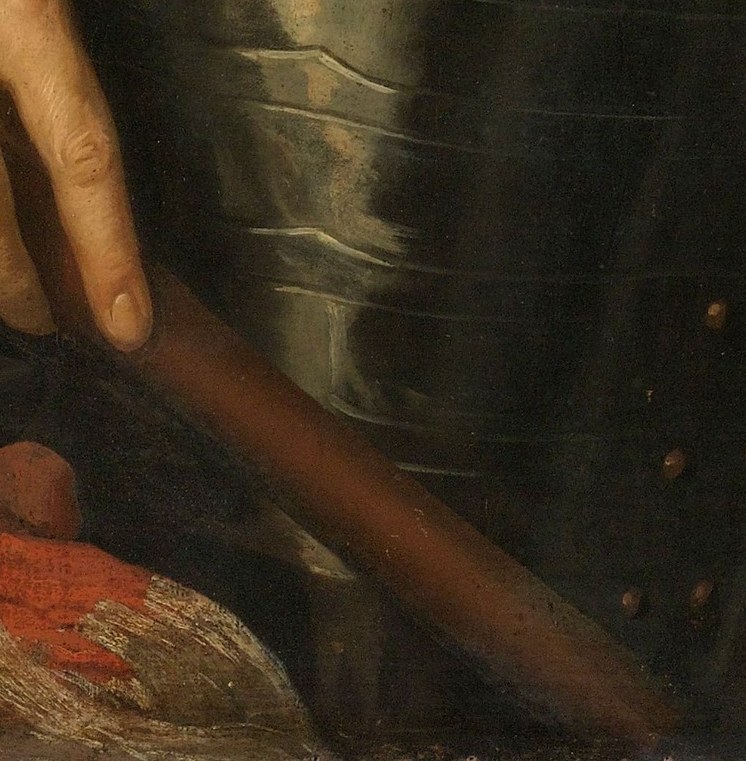 He holds a command baton, a symbol of his authority.