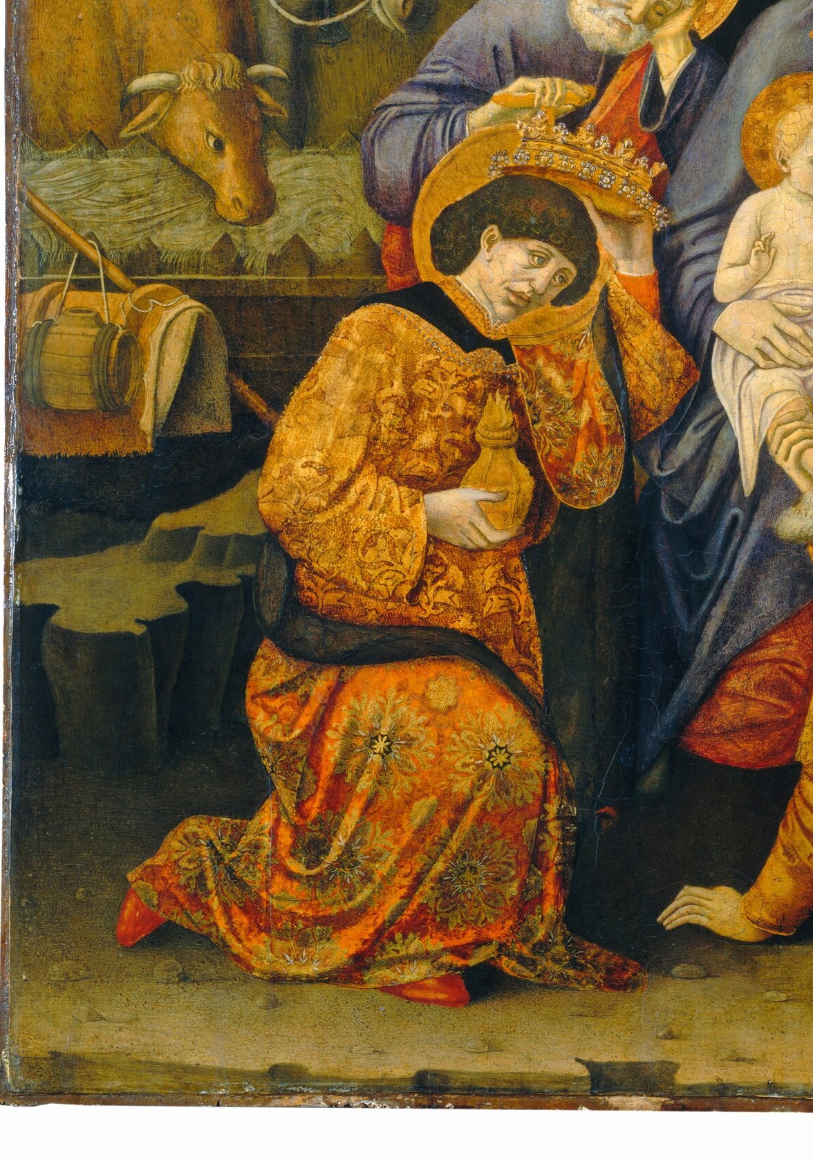 The most dramatic gesture of submission in the composition , a crowned king face-down before an infant; his jeweled robe against the bare stable floor crystallizes the painting's central paradox.