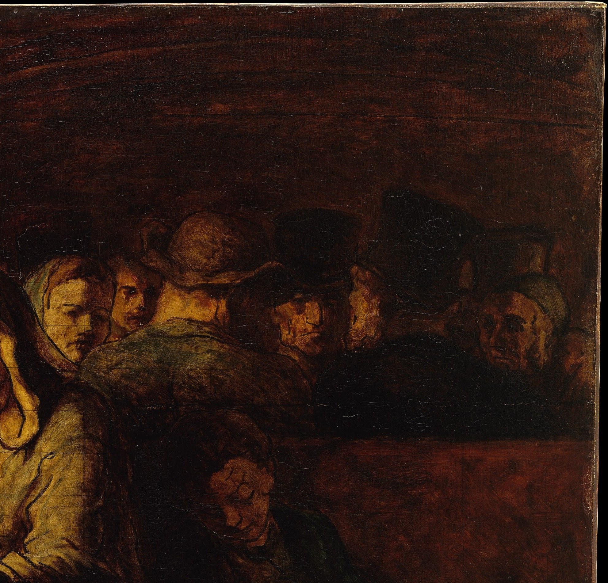 The carriage is dark. The passengers are packed tight.