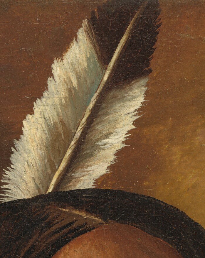 Look closely at the single feather tucked into his hair.