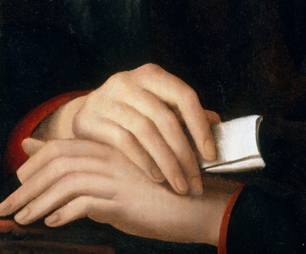 His folded hands suggest quiet contemplation.