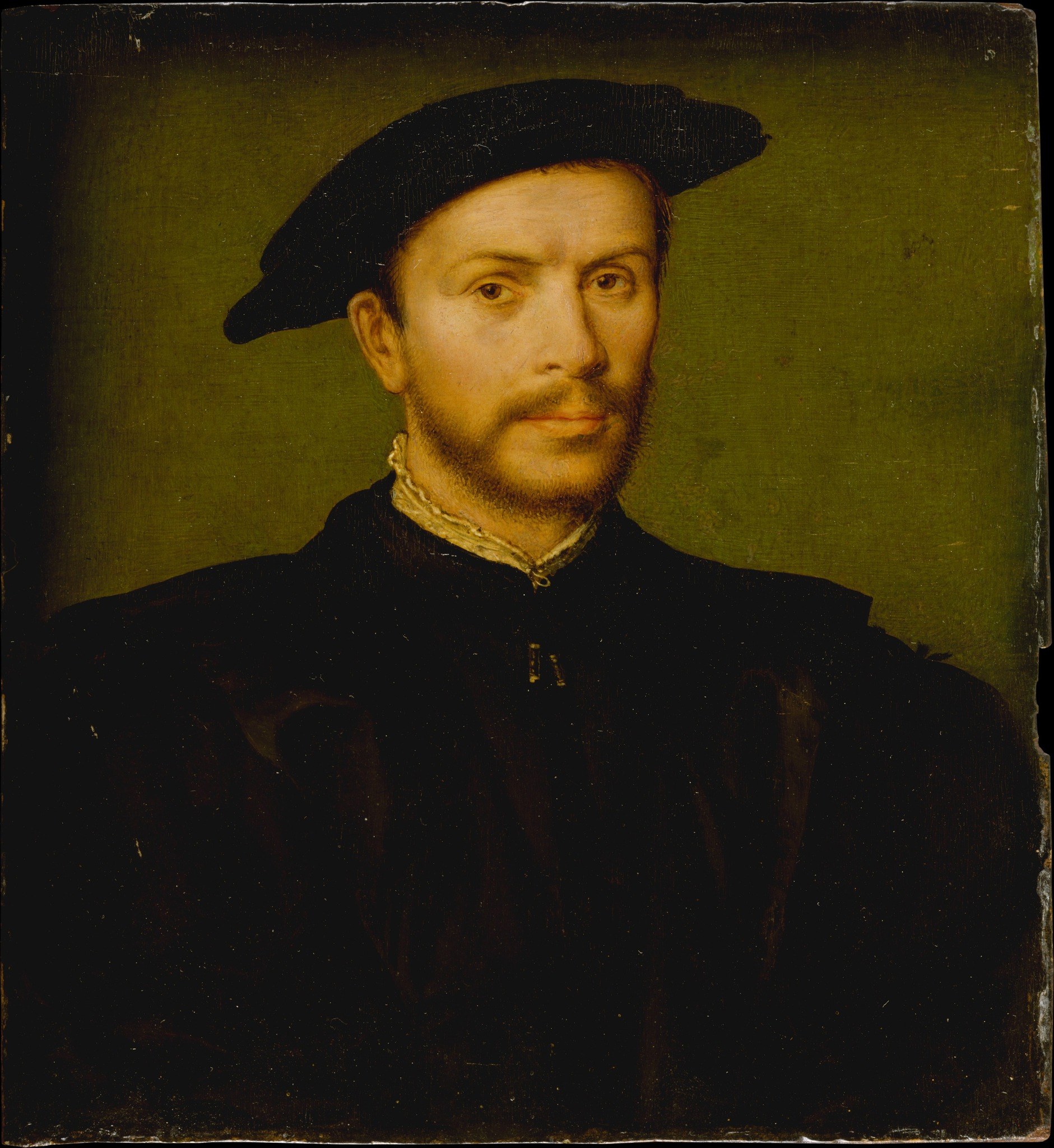 The plain, uniform background isolates the subject, intensifying the focus on his presence and expression.