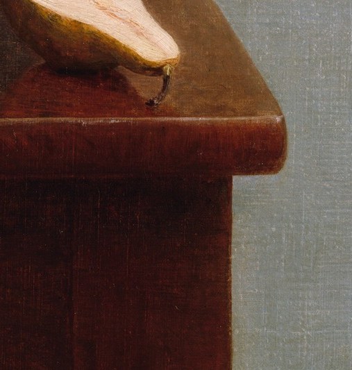 A single cut pear, with a knife left resting beside it.