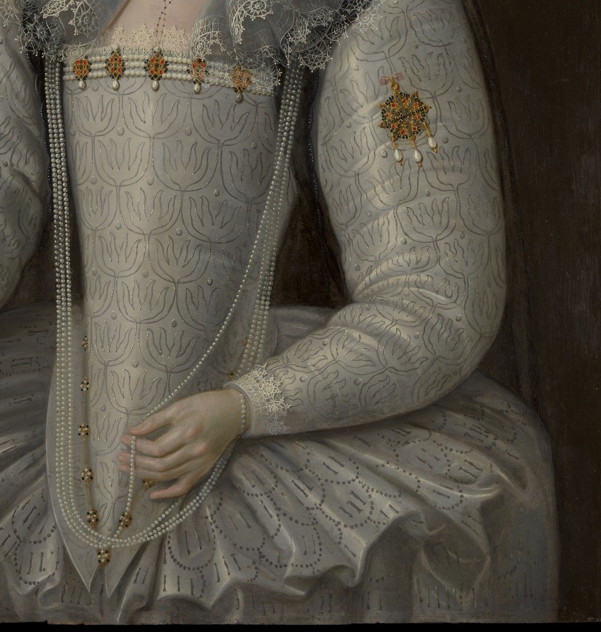 The detailed embroidery and sheen of the fabric highlight the luxurious textiles and skilled craftsmanship of the period.