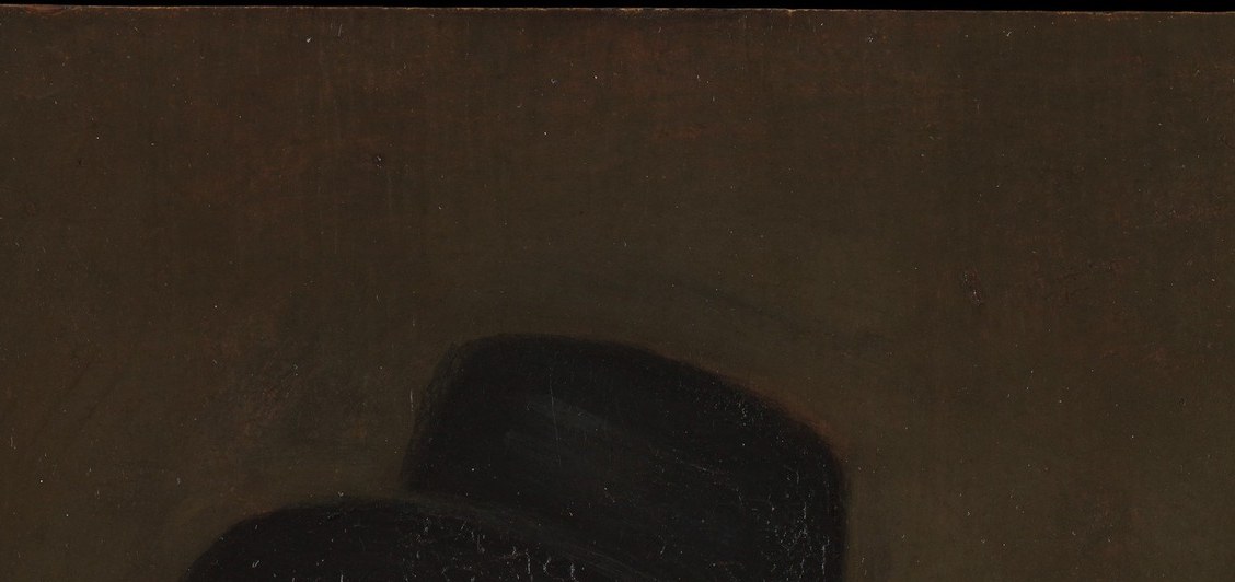 The hat's broad brim casts subtle shadow over the upper forehead and merges into the dark background, flattening the top of the composition intentionally