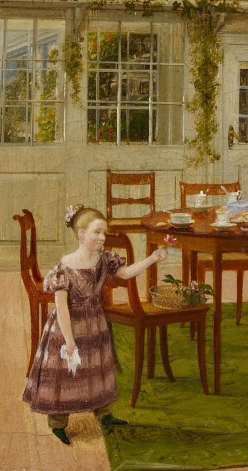 Her outstretched arm toward the table suggests she is offering or reaching for something , a naturalistic, unposed gesture that keeps the scene from feeling like a stiff portrait.