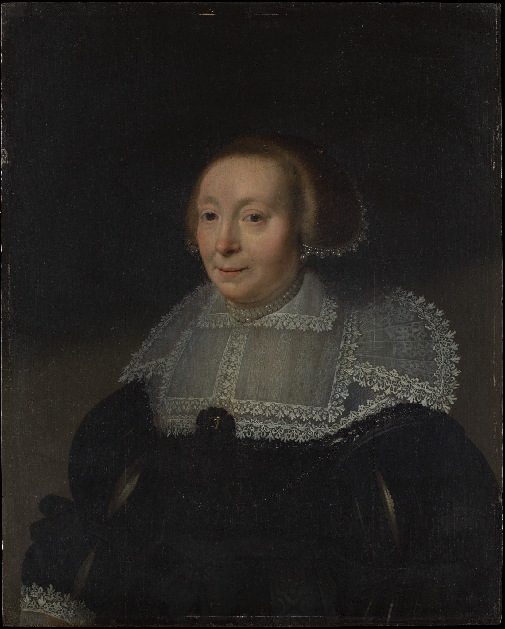 The dark background isolates the figure, focusing all attention on her and her attire.