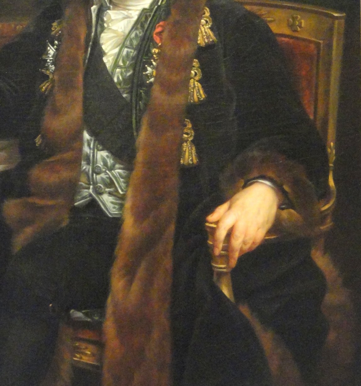 The luxurious fabric and rich texture of the robe signify his status and importance.