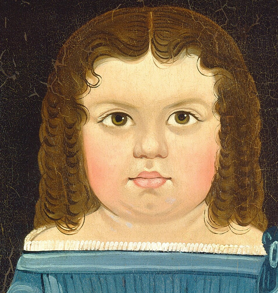 Her round face and direct gaze convey a sense of innocence and perhaps a touch of solemnity.
