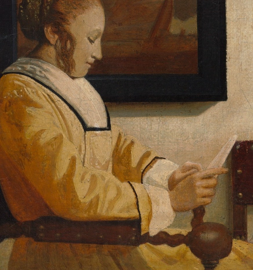 Her posture and focused gaze convey a sense of quiet contemplation and engagement with the text.