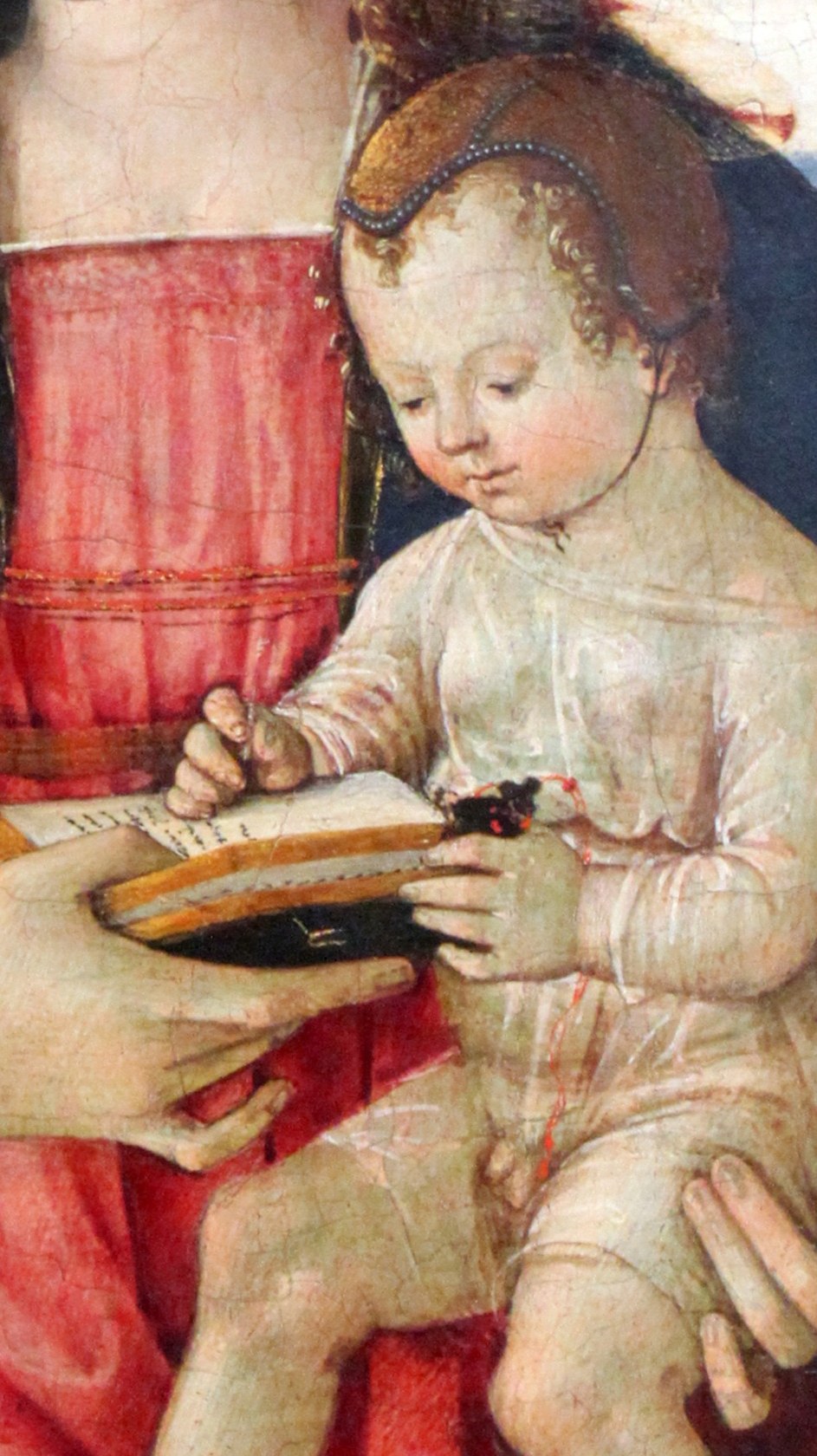 His plump form and curious engagement with the book suggest both divine nature and human infancy.