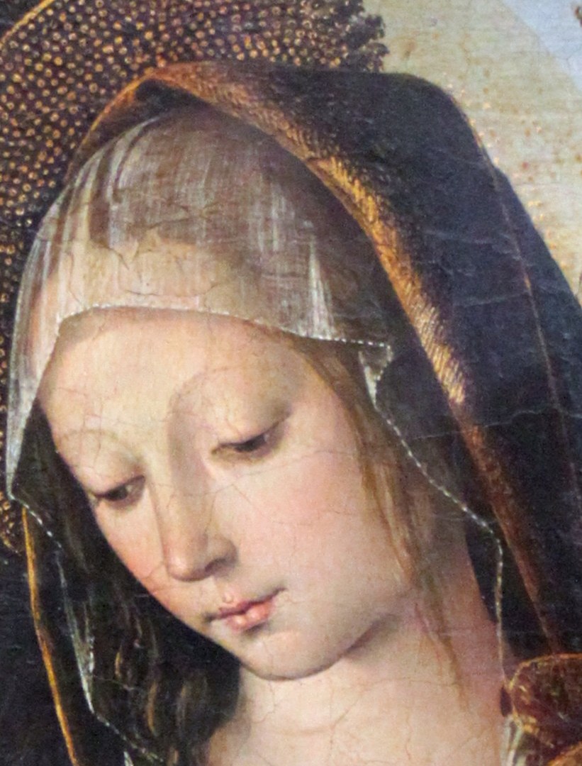 Her gentle gaze and serene expression convey maternal love and a sense of divine peace.