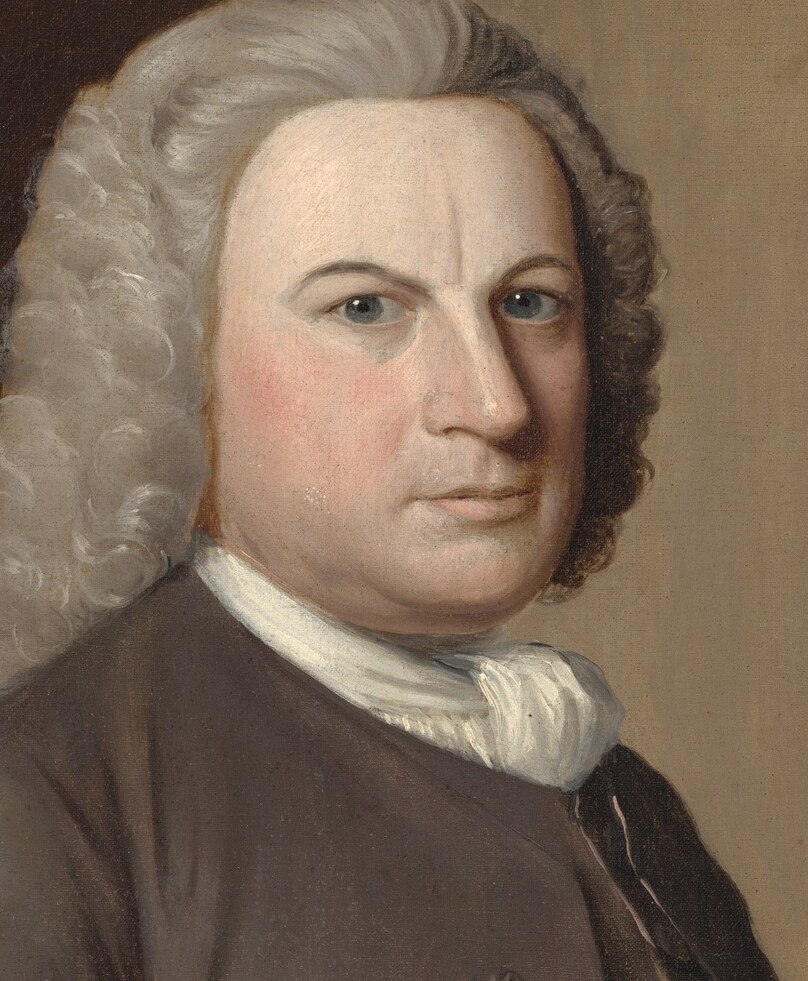His direct gaze and slightly downturned mouth convey a serious, perhaps even stern, demeanor, hinting at his personality and status.