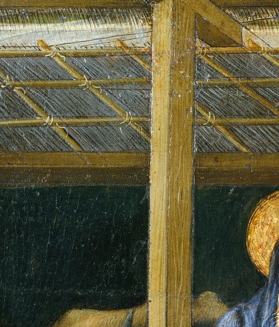 Her downward gaze and serene expression anchor the devotional mood; the gold halo catches light against the dark stable interior.