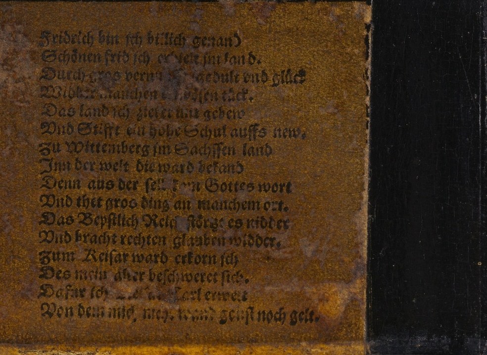 Look closely at the inscription below his shoulder.