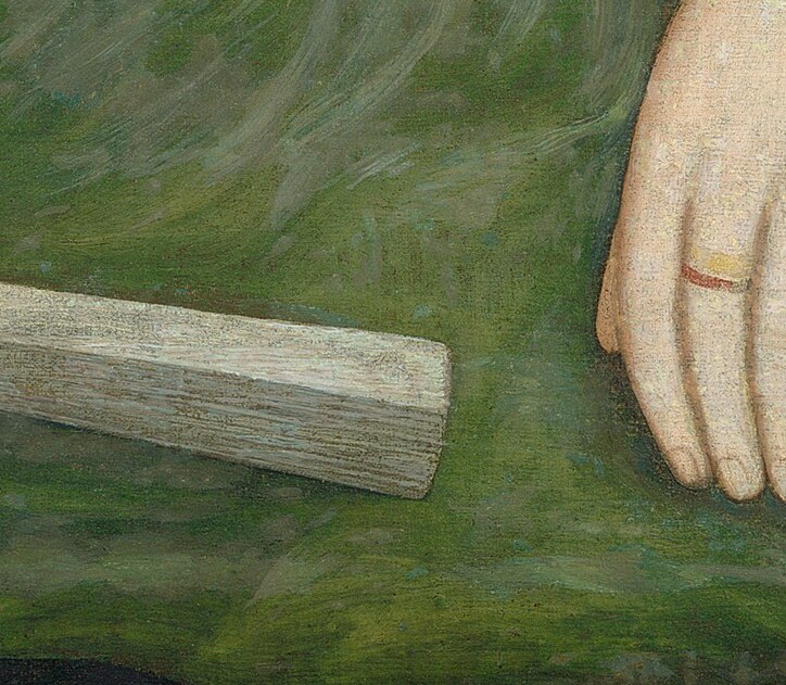 Her hands hold a simple, folded fan, a common accessory.