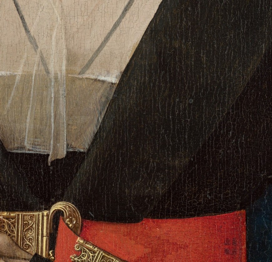 In her right, she holds a flower, a personal gesture.